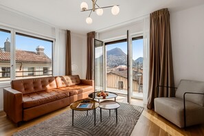 A modern living room with a leather sofa, a small coffee table, and a patterned rug. - Novos Contrada Apartments (Lugano)
