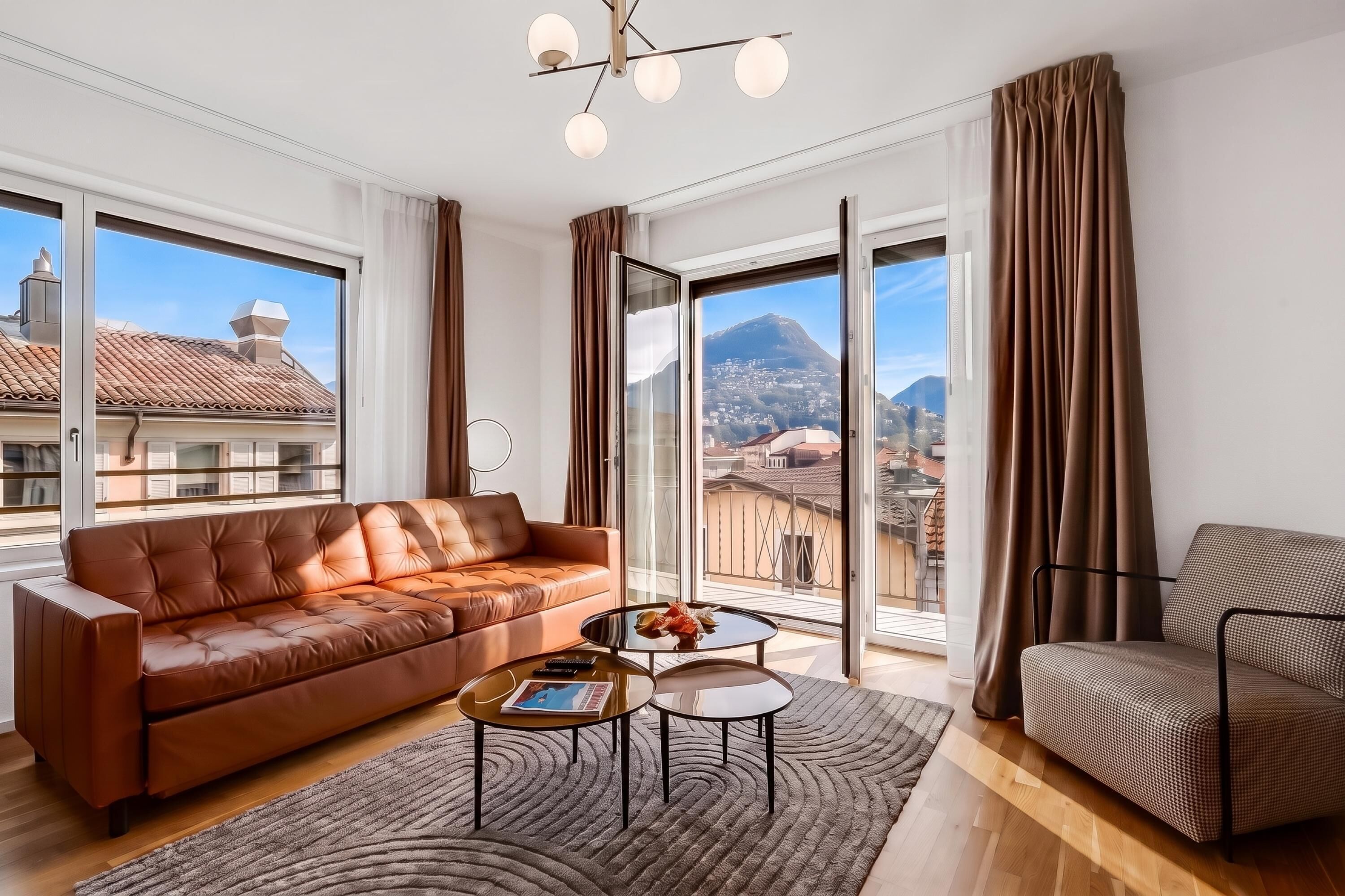 Una sala de estar moderna con un sofá de cuero, una mesa de centro y vistas a un paisaje urbano a través de amplios ventanales.