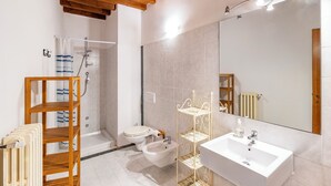A modern bathroom with a shower, toilet, bidet, wooden shelves, and a large mirror. - Villa Salivolpe Amazing Chianti View (San Casciano in Val di Pesa)