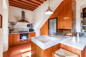 A modern kitchen with wooden cabinetry, a built-in oven, a microwave, and a large island with a sink. - Villa Salivolpe Amazing Chianti View (San Casciano in Val di Pesa)