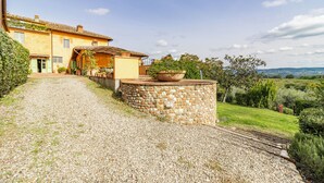 A rustic stone pathway leading to a yellow building with a tiled roof, surrounded by greenery and a view of distant hills. - Villa Salivolpe Amazing Chianti View (San Casciano in Val di Pesa)