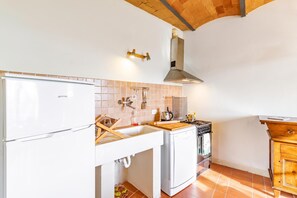 Une cuisine avec un réfrigérateur blanc, une cuisinière et un évier.