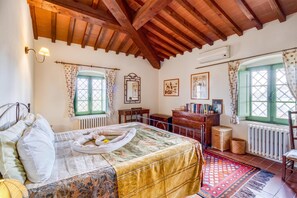 A bedroom with a bed, a dresser, a chair, a window, and a radiator. - Villa Salivolpe Amazing Chianti View (San Casciano in Val di Pesa)