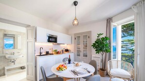 Una cucina moderna con mobili bianchi, un tavolo da pranzo apparecchiato e vista sull'esterno.