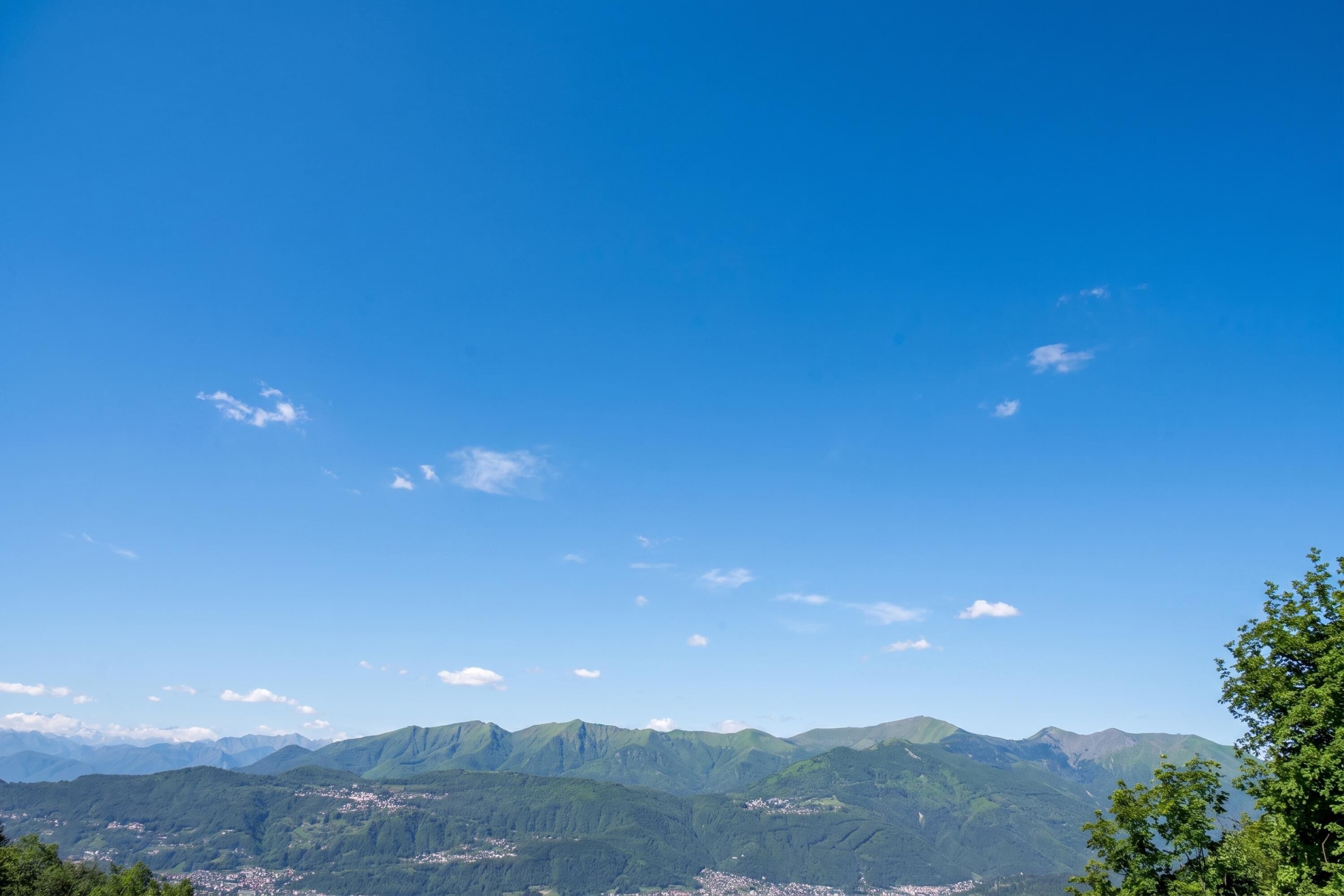 Eine gebirgige Landschaft mit blauem Himmel und vereinzelten Wolken.