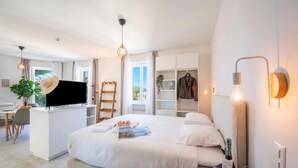 Una moderna camera d'albergo con un letto, una scrivania, una TV e vista sull'esterno.