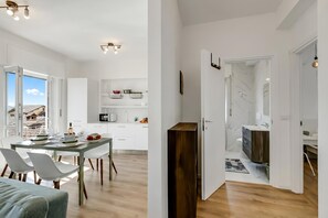 Un interior moderno con comedor, cocina y baño.