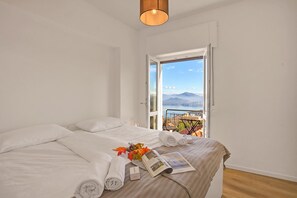 A bedroom with a bed, a window, and a view of a landscape. - Luce Lake View on Stresa Hill (Stresa)