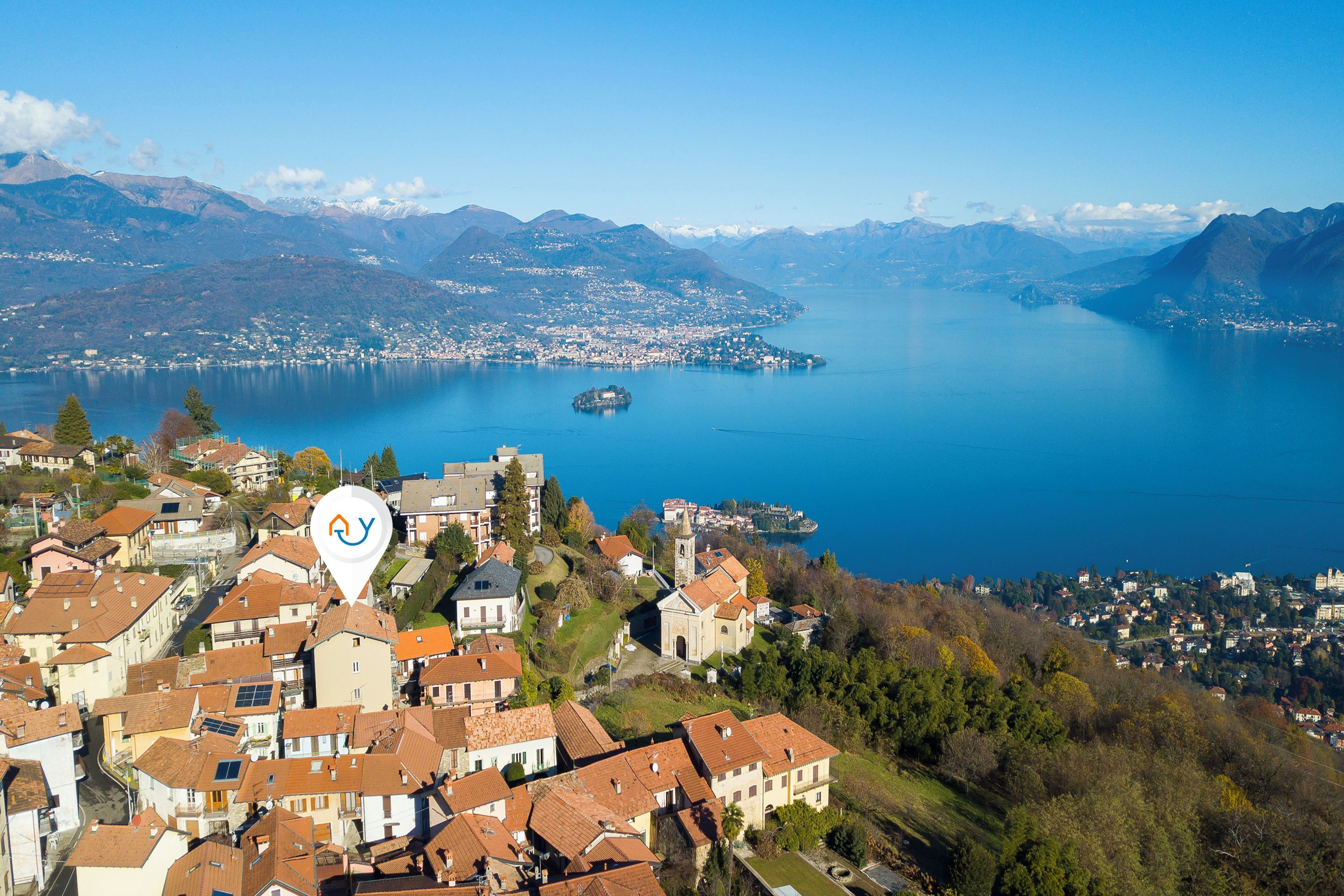 A coastal town with terraced houses, a church, and a lake.