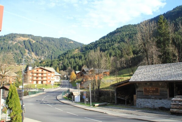 A mountain road leading to a rustic lodge with a sign reading "SCIERIE DE VILLAPYRON".