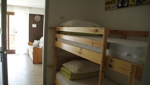 A bunk bed with a wooden frame and a mattress on the top bunk. - Apartment in Portes du Soleil (Châtel)