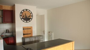 Una cocina con encimera de madera, un reloj decorado con ciervos y árboles, y un radiador.