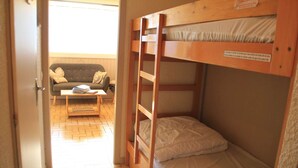 A room with a bunk bed, a sofa, and a coffee table. - Apartment in Châtel near Cable Car (Châtel)