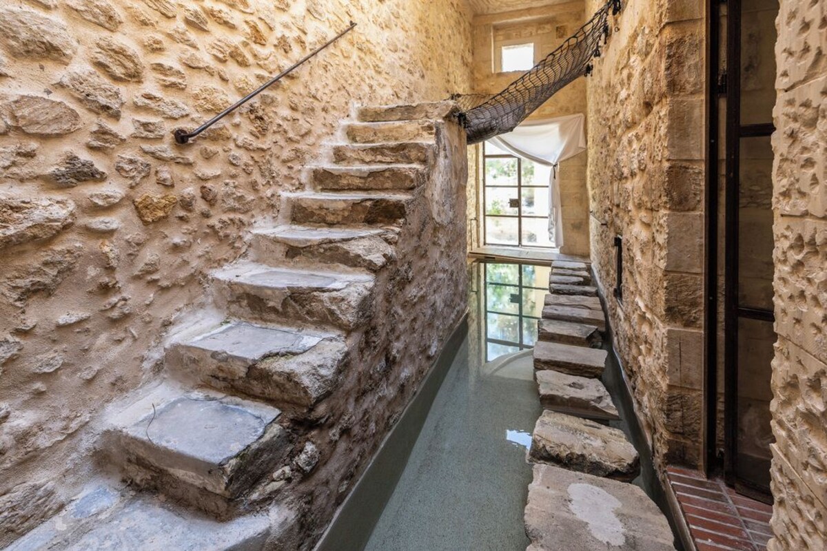 A narrow stone staircase with a glass-bottomed water channel running alongside it.