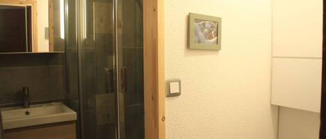 Une salle de bain avec une douche à parois de verre, un lavabo et des toilettes.