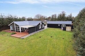 Il s’agit d’une propriété résidentielle dotée d’une grande pelouse, d’une maison avec un toit en pente et d’un garage séparé.