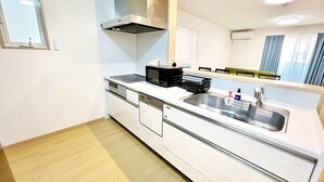 Een compacte keuken met een RVS spoelbak, een magnetron en een inbouwoven.