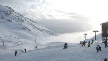 Une piste de ski enneigée, avec des skieurs et des snowboardeurs.