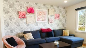 A modern living room with a dark blue sectional sofa, a pink chair, and a coffee table. - Entire House * Kid Ready * Yard (Arvada)