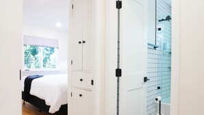 A bedroom with a bed, a wardrobe, and a bathroom with a shower and toilet. - Entire House * Kid Ready * Yard (Arvada)