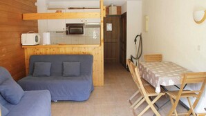 A compact living space with a kitchenette, a sofa, a dining table, and a wooden bench. - Apartment for 3 people in Chatel (Châtel)