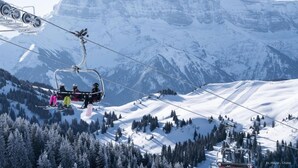 Un télésiège avec des skieurs portant des vestes aux couleurs vives.