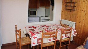 Une cuisine de taille réduite, dotée d’une fenêtre, de meubles en bois, d’un four à micro-ondes et d’une cuisinière.
