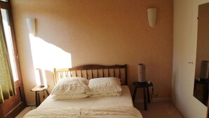 Une chambre à coucher avec un lit, deux lampes de chevet et un miroir au mur.