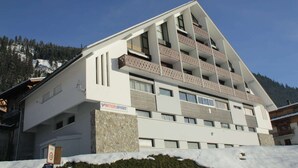 A multi-story hotel with balconies, a stone facade, and a sign indicating "INTER SPORT".