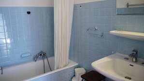 A bathroom with a bathtub, a sink, and a toilet.