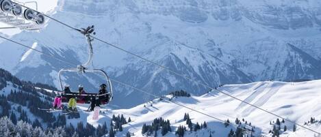 A ski lift with skiers in colorful jackets.