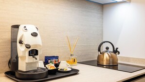 A coffee machine, tea bags, a teapot, and a diffuser with reed sticks on a tray. - Nora's Suites (Palermo)