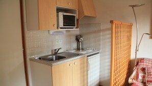 Una cocina compacta con microondas, pileta y lavavajillas.