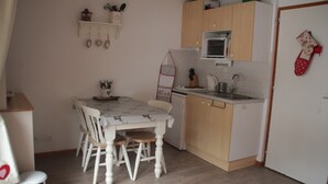 A compact kitchen with a dining table and chairs, a microwave, and a sink. - Apartment near Ski area in Chatel (Châtel)