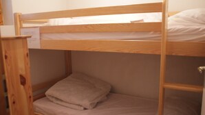 A bunk bed with a wooden frame, a lower bunk with a pillow, and a mattress. - Apartment near Ski area in Chatel (Châtel)