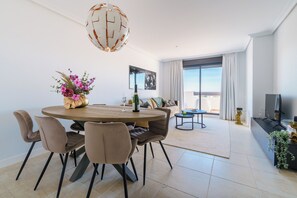 A modern dining area with a round table, chairs, and a decorative centerpiece. - Luxe Golf & Family House Escape (Estepona)