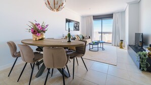 A modern dining area with a round table, chairs, and a decorative centerpiece. - Luxe Golf & Family House Escape (Estepona)
