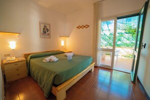 Un dormitorio con cama, lámparas de noche, un teléfono y vistas al exterior.