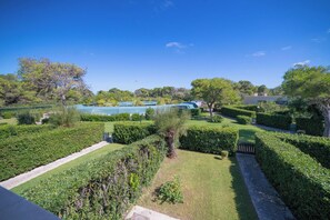 A well-maintained garden with neatly trimmed hedges, a clear pathway, and a view of a building in the distance. - Villa 1 Sunset with Pool on Seashore (Otranto)