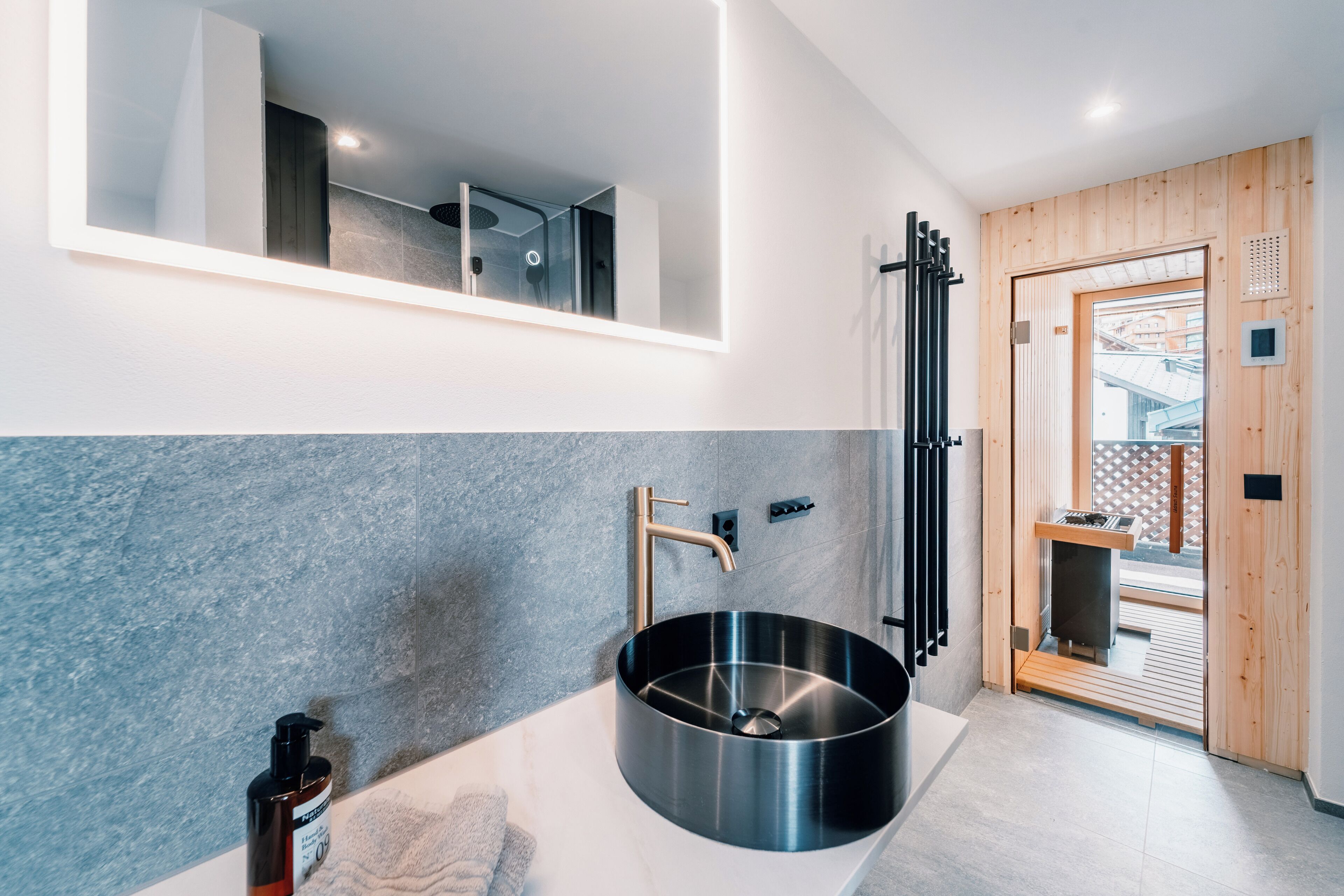 Un baño moderno con un lavamanos grande, un espejo y una zona de ducha.