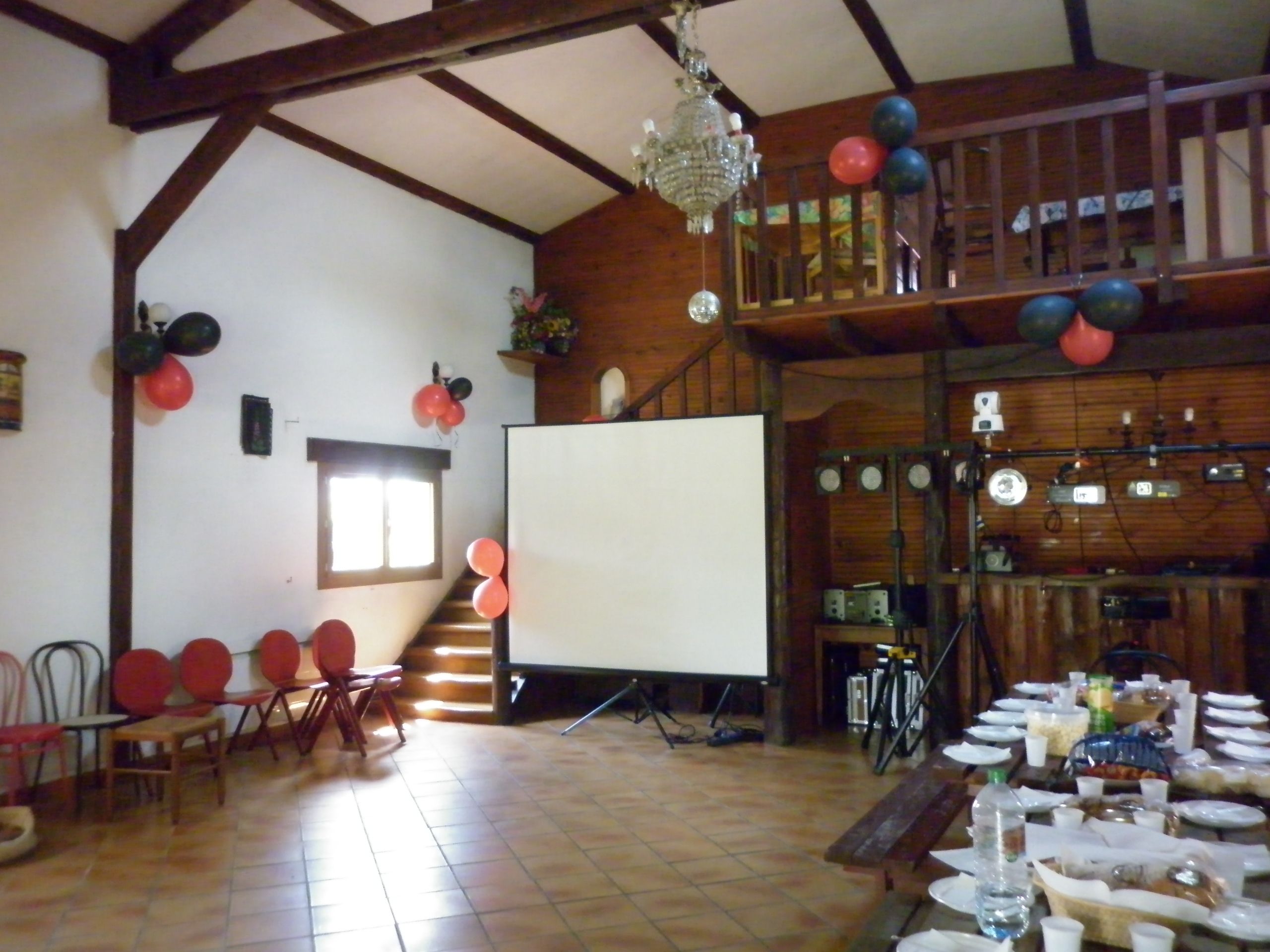 A spacious hall with a stage, chairs, and tables set up for an event.