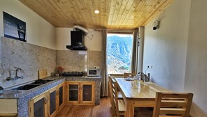 Une cuisine avec des armoires en bois, des comptoirs en granit, une cuisinière et un four à micro-ondes.