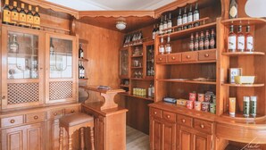 A wooden bar area with shelves of bottles, glasses, and condiments. - Guesthouse Beach Break (Peniche)