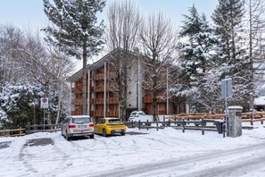 A building with multiple balconies, a snow-covered landscape, and a no parking sign. - Residence Dolonne (Courmayeur)