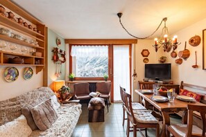 Un salon confortable avec un canapé, une table à manger, des chaises et un téléviseur.