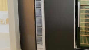 A room with a partially open wardrobe revealing a white interior.