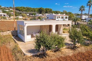 A modern house with a flat roof, large windows, and a patio area.