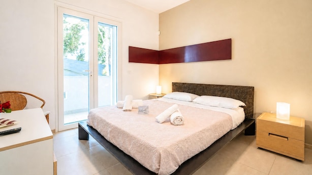 A hotel room with a bed, bedside tables, a desk, and a chair. - Villa Torricella Pool and Sunny Garden (Leverano)