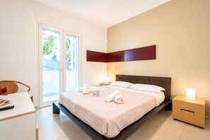 Une chambre d’hôtel avec un lit, des tables de chevet, un bureau et une chaise.