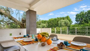 An outdoor dining area with a table set for breakfast, featuring fruits, pastries, and a view of the surrounding greenery. - Villa Torricella Pool and Sunny Garden (Leverano)
